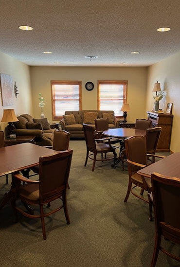 Community room with tables and chairs at Good Samaritan Society - Hastings Village.