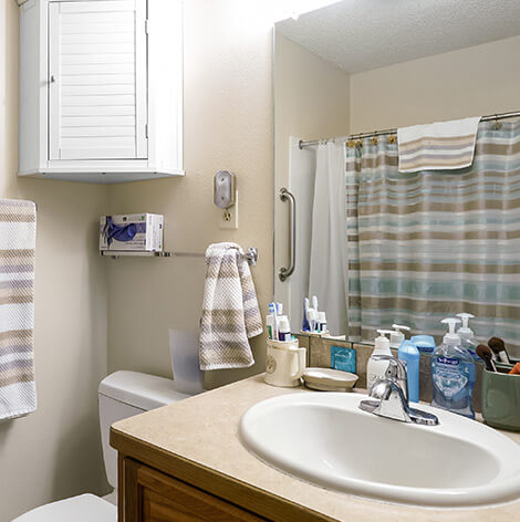 Assisted living apartment bathroom with walk-in shower at Good Samaritan Society - Loveland Village in Loveland, Colorado.
