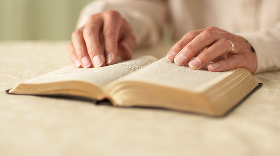 Hands on an open Bible.