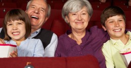 Grandfather and grandmother in a movie theater with young granddaughter and grandson