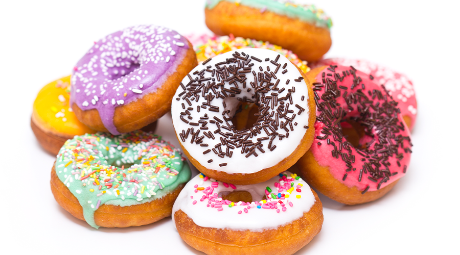 Delicious stack of donuts with frosting and sprinkles.