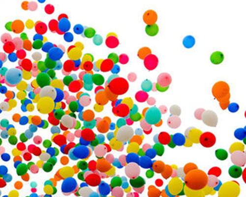 Lots of colorful balloons floating into the air.
