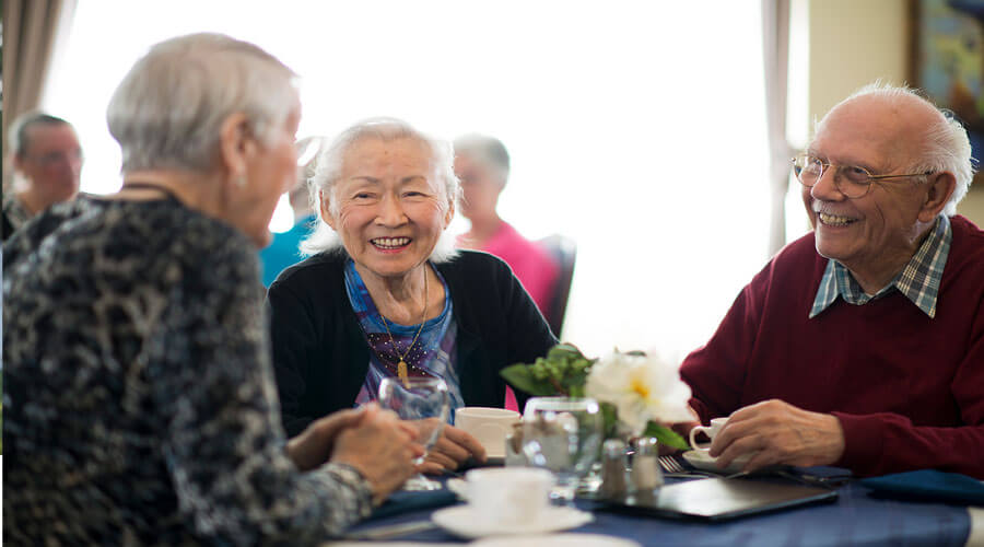 Three people chatting at a dinner table.