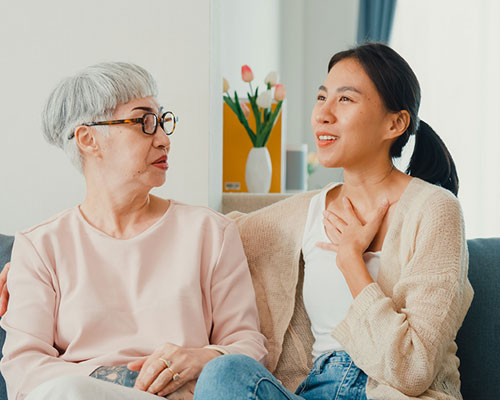 2 women having a conversation on the couch.