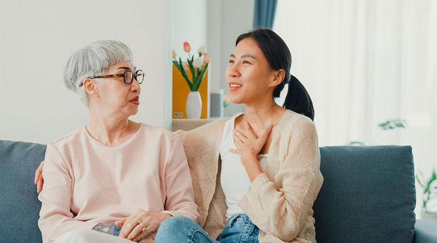 2 women having a conversation on the couch.