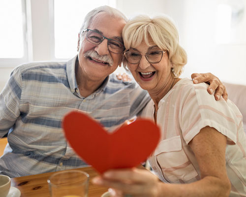 Senior couple holding a paper heart.