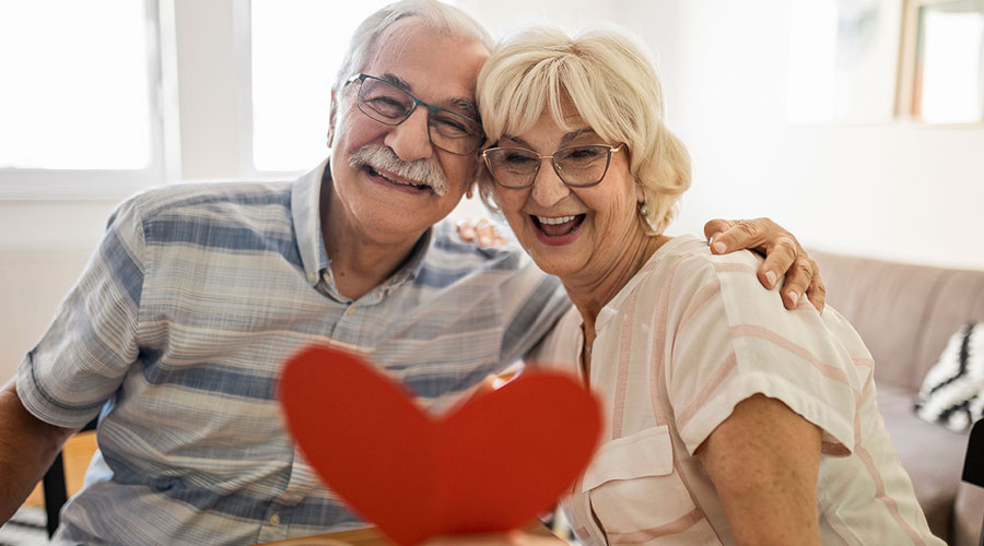 Senior couple holding a paper heart.