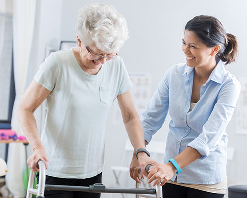 Woman assisting a lady with a walker.