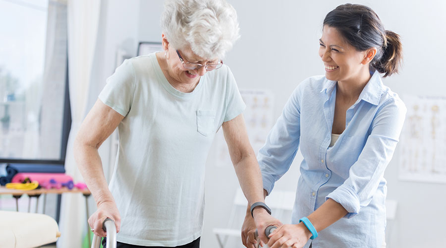 Woman assisting a lady with a walker.