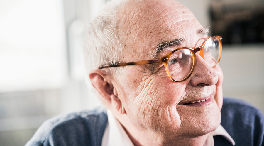 Older man with glasses smiling.