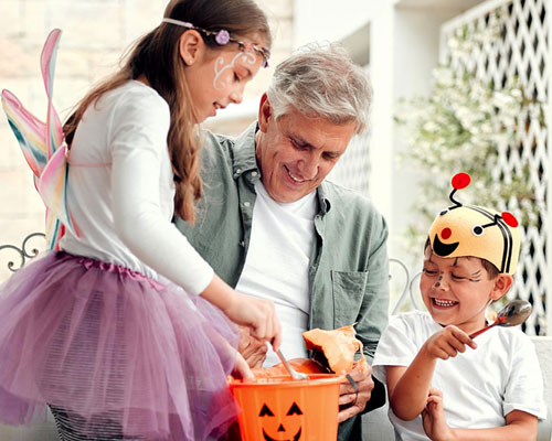 Kids in costumes collecting candy during trick or treating.