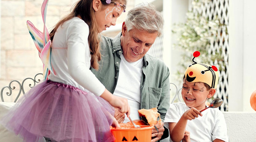 Kids in costumes collecting candy during trick or treating.