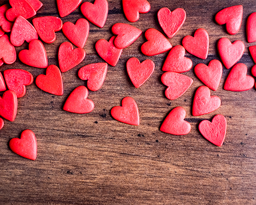 Candy hearts on a wood table.