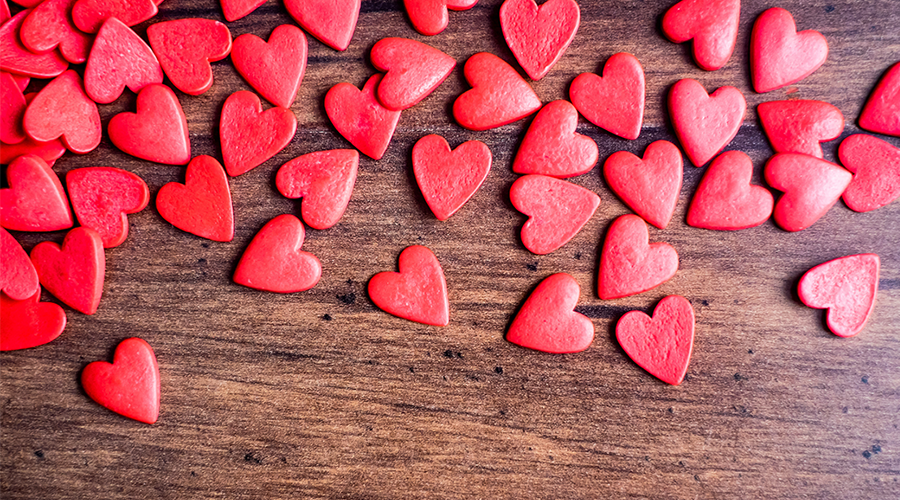 Candy hearts on a wood table.