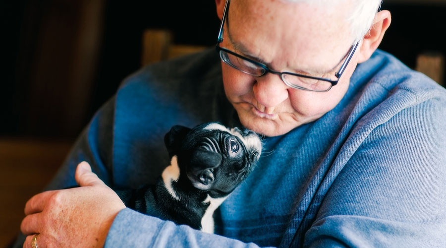 Senior man holding a puppy.