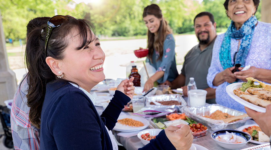 Group of people eating at a picnic.