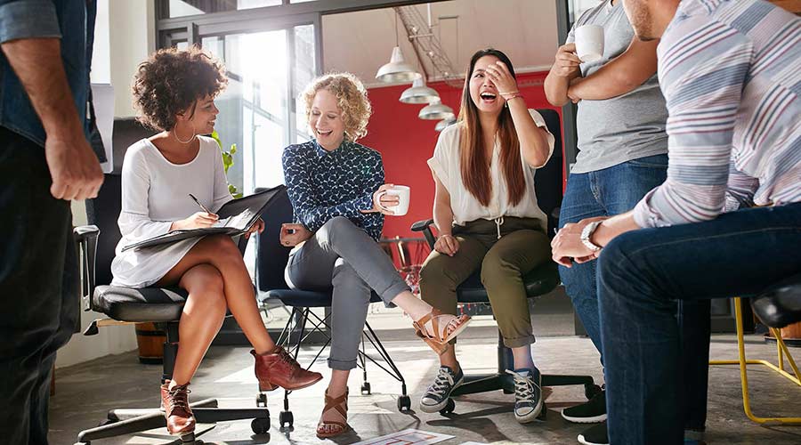 Group of adults sitting in a conference room having a meeting. 