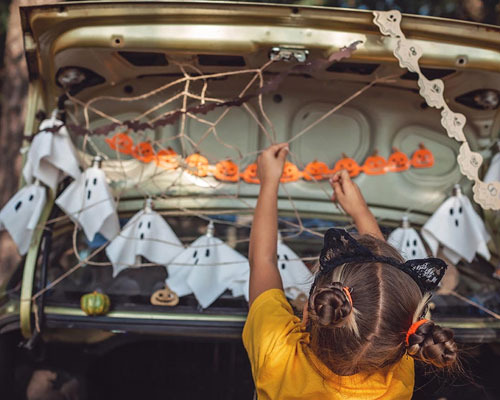 Young girl decorating for Trunk or Treat.