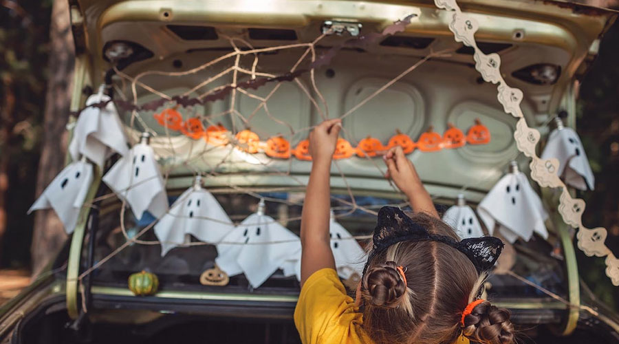 Young girl decorating for Trunk or Treat.