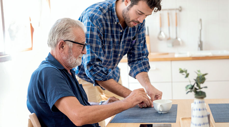 Two men doing a craft at a kitchen table.