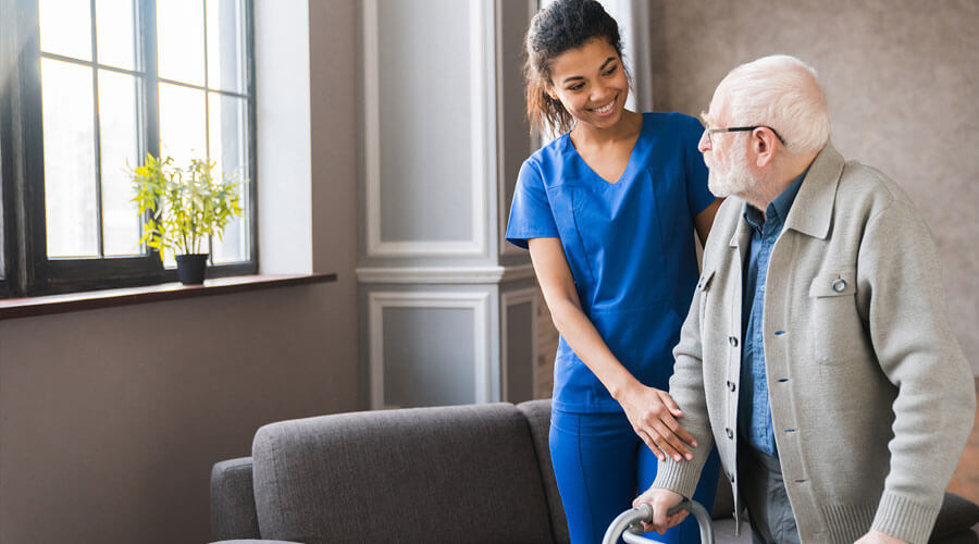 Nurse helping a man with a walker