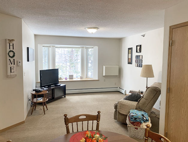 Independent living apartments provide spacious living rooms with natural light at Good Samaritan Society - Hidewood Estates in Clear Lake, South Dakota.