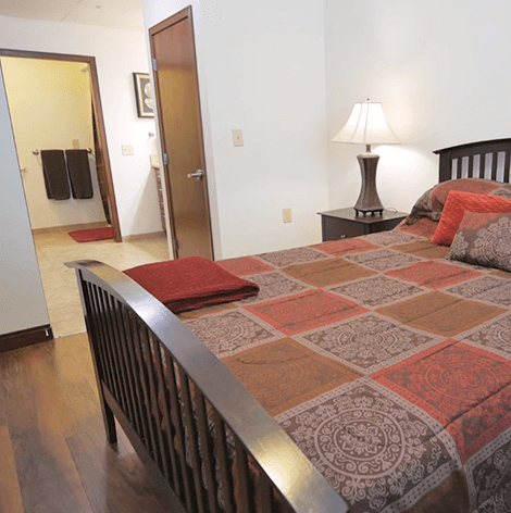 Good Samaritan Society - Grand Island Pelican Falls independent living apartment bedroom with walk-in bathroom