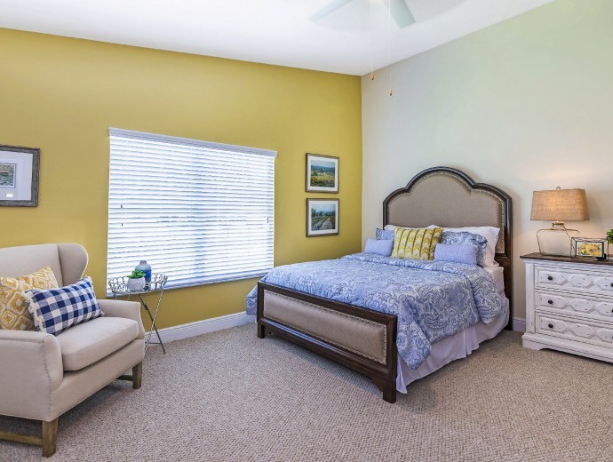 Large master bedroom with oversized picture window available in the Gables apartments at Good Samaritan Society - Kissimmee Village in Kissimmee, Florida.