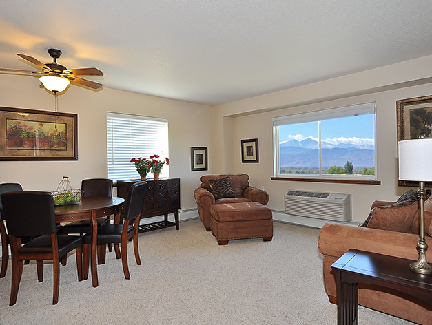 Spacious living room perfect for entertaining with a view of the majestic mountains at Good Samaritan Society - Loveland Village in Loveland, Colorado.