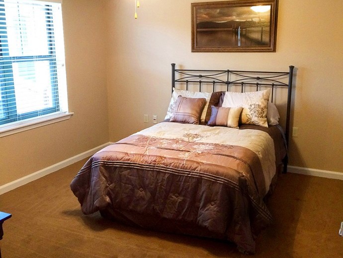 Senior living apartment bedroom with natural light at Good Samaritan Society - Mountain Home in Mountain Home, Arkansas.