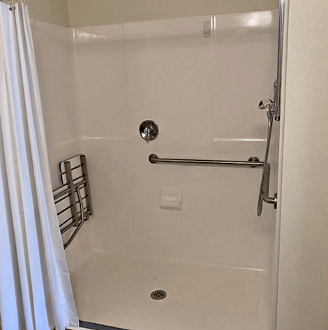 Timber Ridge Assisted Living apartment walk-in shower with a pull down seat, handrails and easy to handle shower sprayer.