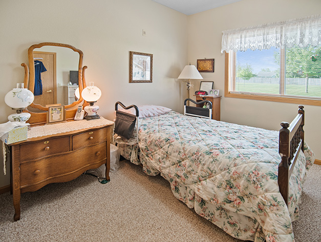 Assisted living apartment bedroom with window view at Good Samaritan Society - St. James in St. James, Minnesota.