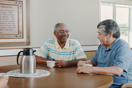 Two senior gentlemen talking over a cup of coffee.