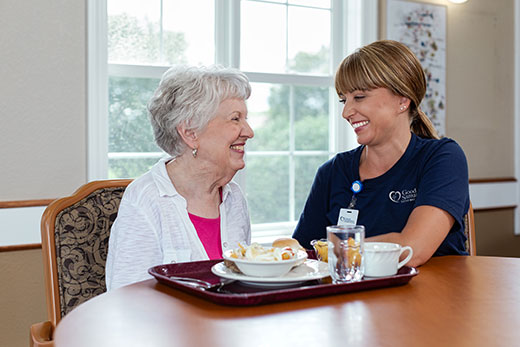 Senior eating lunch with a nurse.