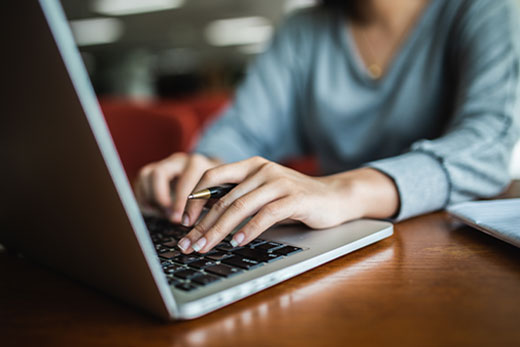 Woman typing on a computer.