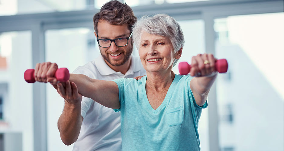 physical therapist helping a patient lift weights
