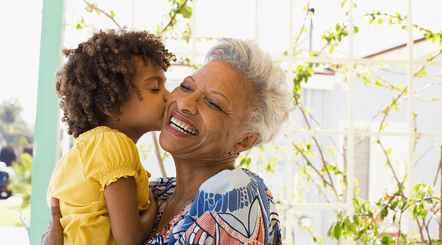 young child kissing their grandmother on the cheek