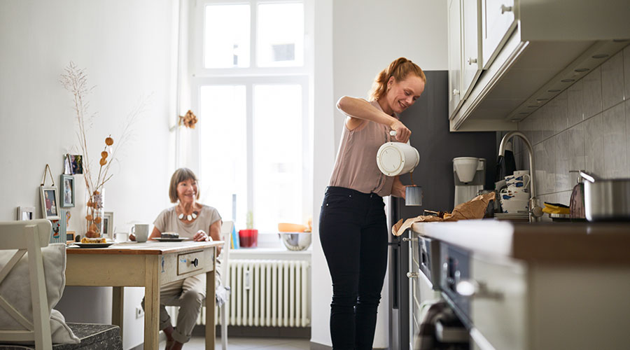 Daughter talking with her mother in a apartment kitchen
