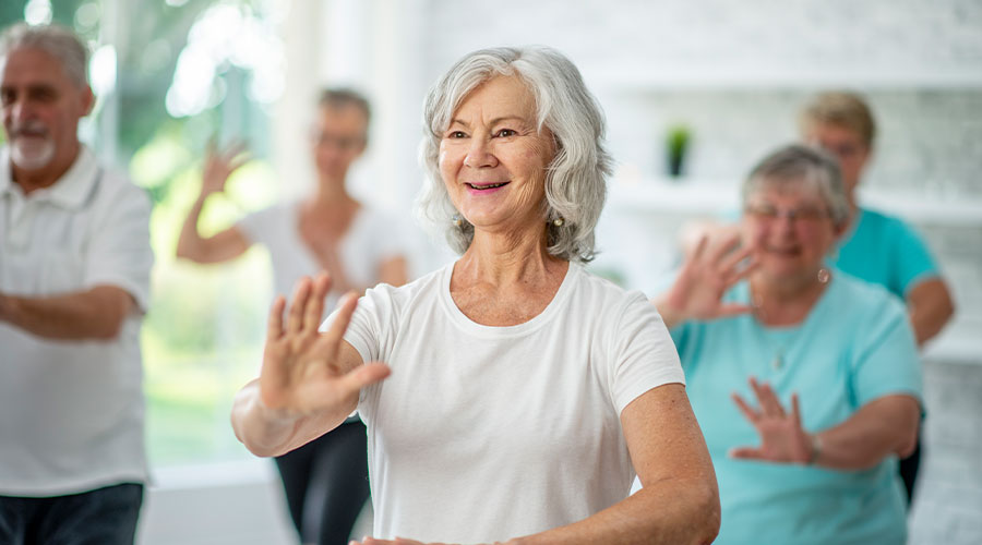 Group of senior adults participating in a Tai Chi course at an independent living community.