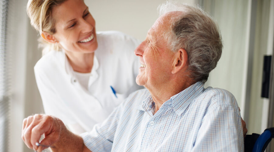 Elderly man speaking to a palliative care nurse