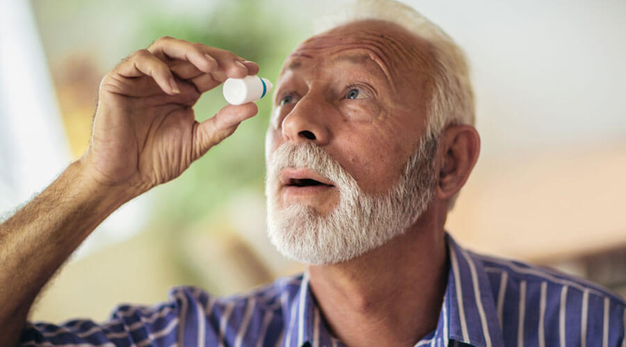 Man putting in eye drops.