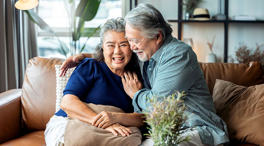 Husband and wife embracing while sitting on a couch