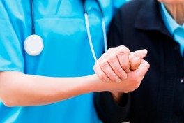 A resident holds the hand of a staff member