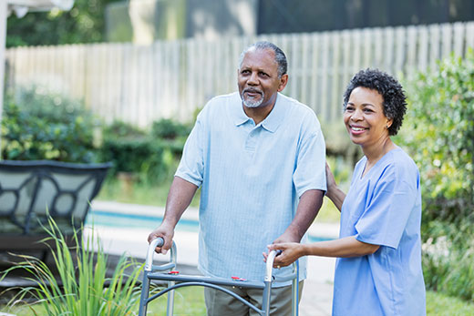 Man being assisted while using his walker.