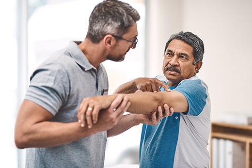 Senior Hispanic man working with a physical therapy to rehab his elbow at Good Samaritan Society.