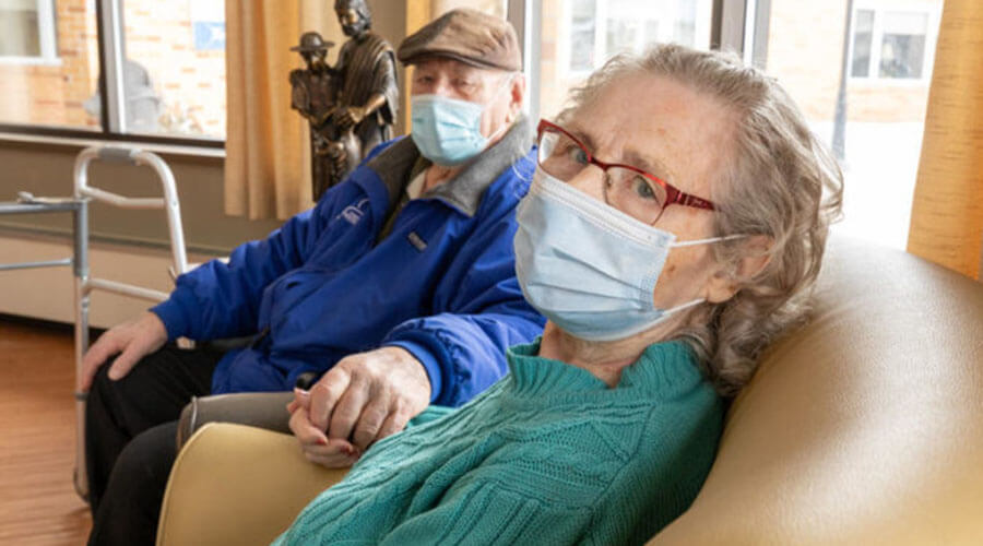 Couple smiling with masks.