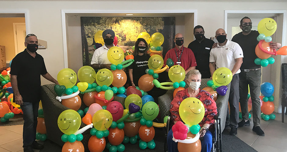 People smiling with fun-shaped balloons.