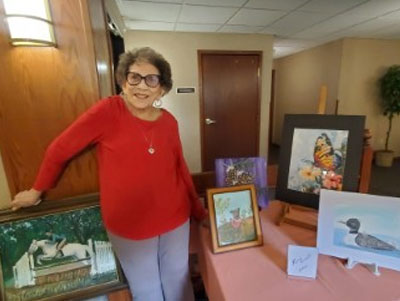 Woman showing her art pieces at the art fair.