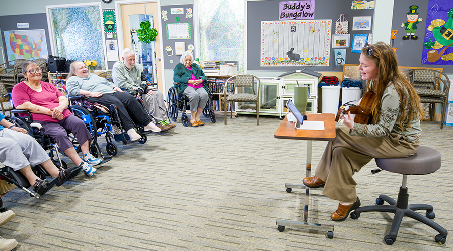 Jenna Steckline playing music for residents on her guitar.