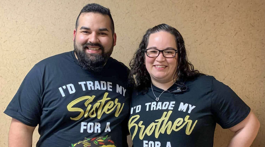 Anthony Arroyos and Christina Mahoney wearing shirts that say they would trade their sibling for a taco.